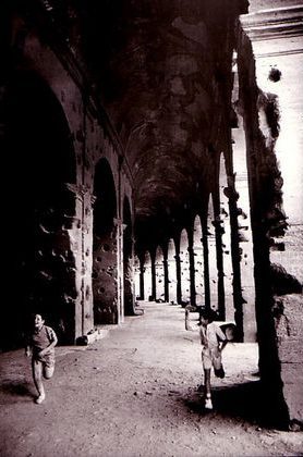 Two boys compete in a running race around the corridors of the Colosseum, Rome